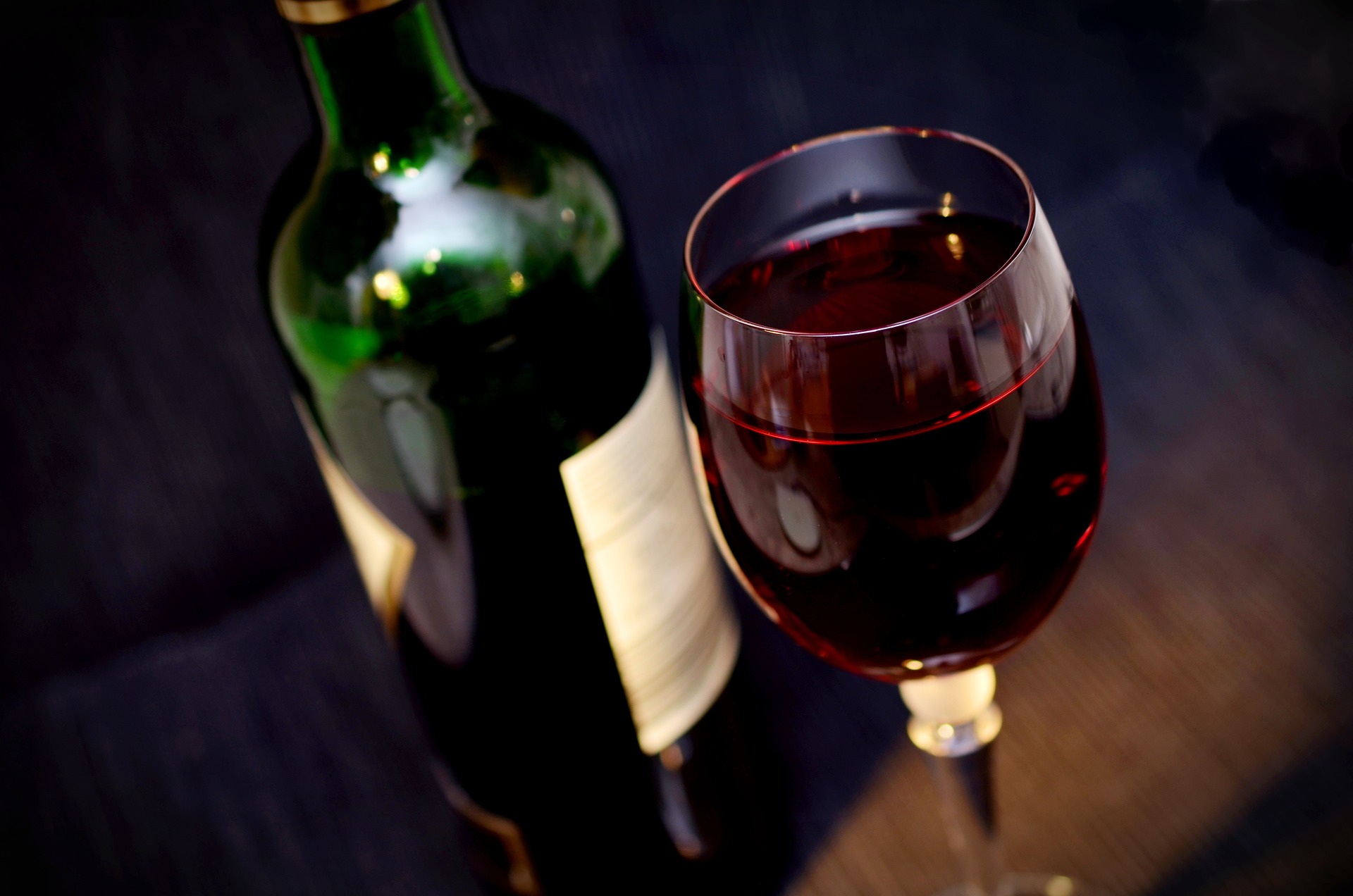 Weinflasche neben einem mit Rotwein gefüllten Glas