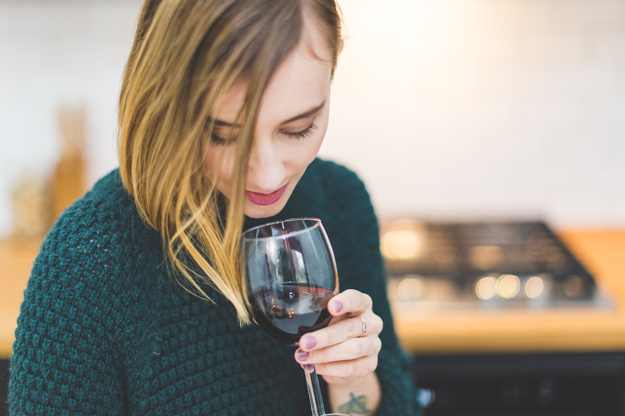 Frau mit Weinglas verkostet Rotwein
